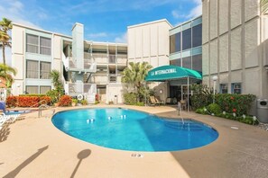 A hotel with a swimming pool, a covered outdoor area, and a sign reading 'LA INTERNACIONAL'. - La Internacional Condominiums #202 (South Padre Island)