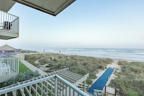 A beach view from a balcony with a pool and a beach path. - La Internacional Condominiums #202 (South Padre Island)
