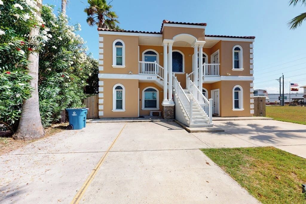 A two-story house with a central staircase, a front porch, and a driveway.