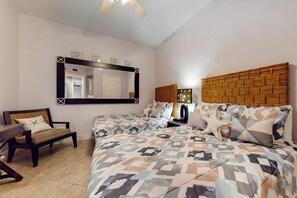 Un dormitorio con una cama grande, un escritorio, una silla, un espejo y un cabecero con luces.