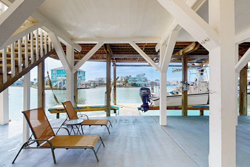 Un espace extérieur abrité offrant une vue sur le port de plaisance, avec un bateau et un yacht.