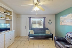 A living room with a sofa, television, and a ceiling fan. - Sand Dollar #5 - Canal-Front, Pool & Pier (Corpus Christi)