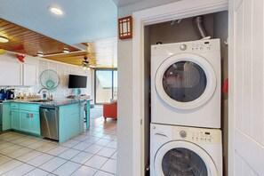 A modern kitchen with a central island, built-in appliances, and a large window. - Mayan Princess - Howdy Lobster (Port Aransas)