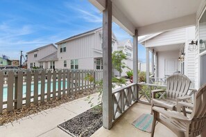 A residential porch with a wooden fence, a pool, and a chair. - Beach Bummz Bungalow (Port Aransas)