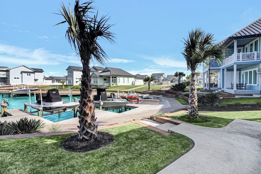 A residential area with houses, a swimming pool, and palm trees.