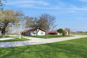 A residential area with a house, a driveway, and a lawn. - R&R Acres - 17 Acres, Wildlife & Grill (Aransas Pass)