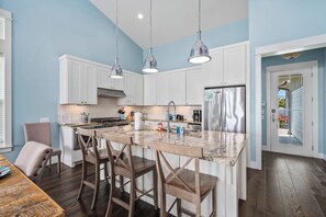 A modern kitchen with white cabinets, a granite countertop, and stainless steel appliances. - Bay Reserve - Bayfront, Private Heated Pool (Rockport)