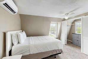 A bedroom with a bed, an air conditioning unit, a ceiling fan, and a window with blinds. - Sandy Toes - Fenced Yard, Blocks to the Beach (Rockport)