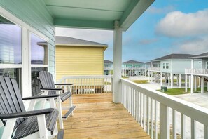 A covered outdoor area with wooden flooring, white railings, and a row of Adirondack chairs. - Rockport Relaxation - Shared Pool, Golf Nearby (Rockport)