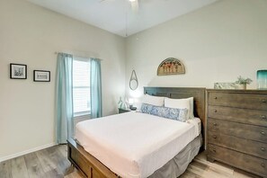 A bedroom with a bed, a dresser, a nightstand, and a window with curtains. - Rockport Relaxation - Shared Pool, Golf Nearby (Rockport)