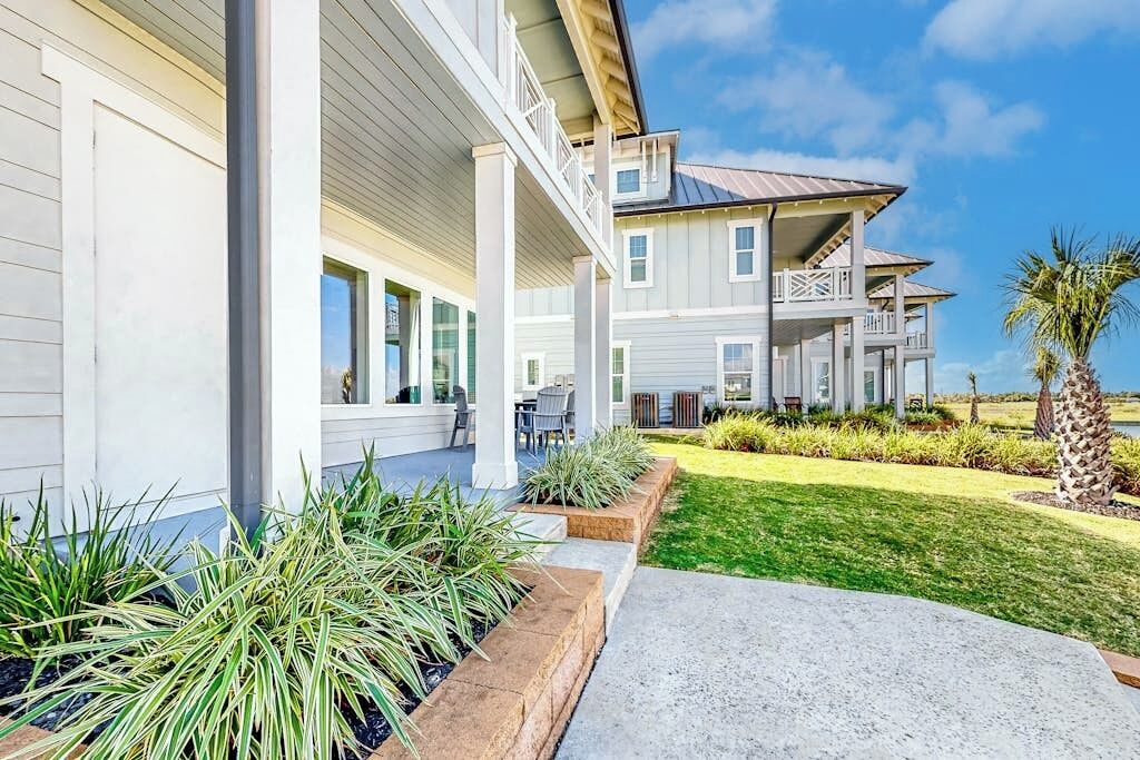 A two-story house with a covered porch and a well-maintained lawn.