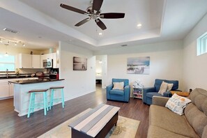 A modern living space with a kitchen, a dining area, and a seating area with a sofa and chairs. - South Pearl Sailfish (Rockport)