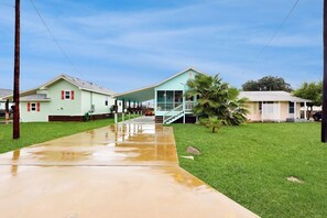 A residential area with houses, a concrete driveway, and a grassy lawn. - South Pearl Sailfish (Rockport)