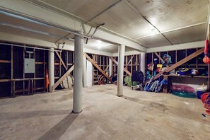 A spacious, unfinished interior with exposed wooden beams, concrete pillars, and various construction materials. - Lost Colony Make A Splash (Port Aransas)