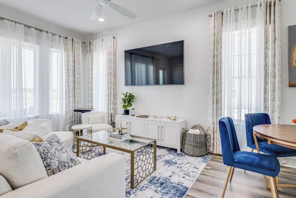 A modern living room with a sofa, coffee table, and dining area.