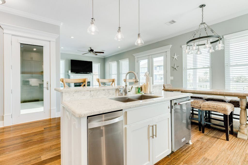 A kitchen with a central island, stainless steel appliances, and a dining area with a bench.