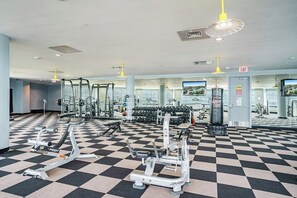 A gym with various exercise equipment, a checkered floor, and multiple mirrors. - Diamond Beach Crown Jewel - #714 (Galveston)