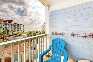 A balcony with a view of a beach and hotel buildings. - Seascape Condos #1222 (Galveston)