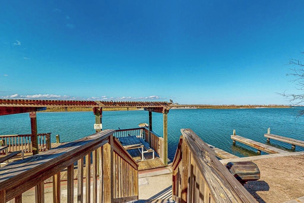 A wooden pier extending into a body of water with a clear sky above.