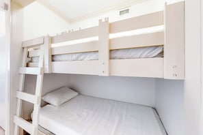 A bunk bed with a ladder, a single bed below, and a headboard with a vent. - Florence Condominiums #303 (South Padre Island)