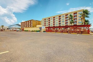 Ein Hotel mit mehreren Stockwerken, einem Parkplatz und einer roten Markise.