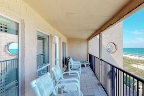 A balcony with white chairs and a view of the beach. - Suntide II Condominiums #509 (South Padre Island)