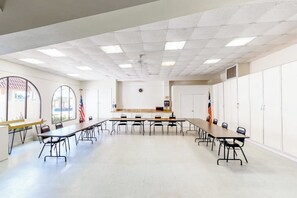 A conference room with a long table, chairs, and a flag. - Long Island Village 347 Sand Dollar (Port Isabel)