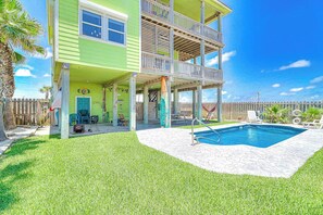 A two-story house with a balcony, a swimming pool, and a fenced yard. - Gulf Breezes Entire Home (Port Aransas)