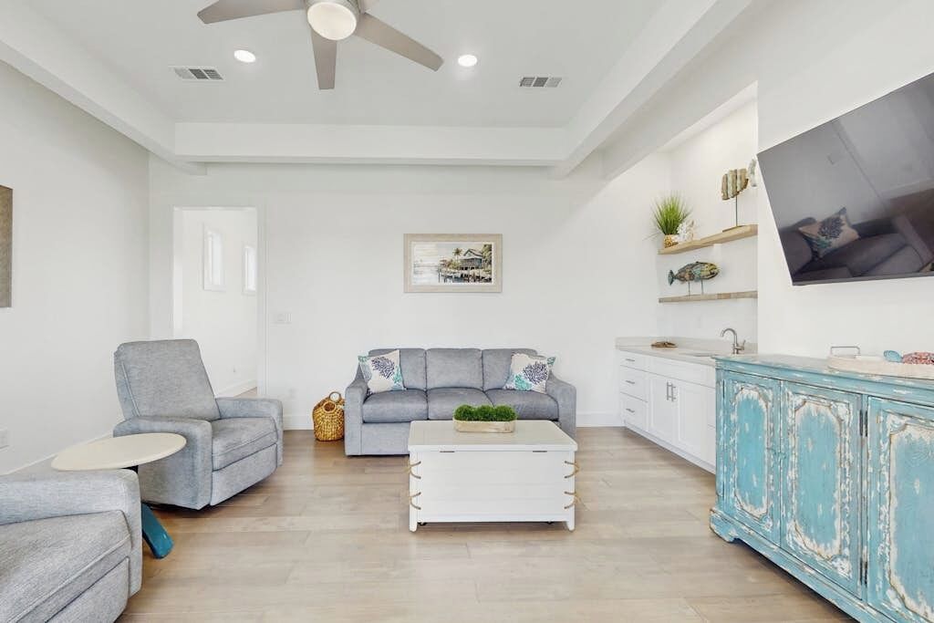 A living room with a grey sofa, a white coffee table, and a blue cabinet.