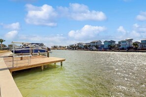 A marina with a wooden dock, boats, and waterfront houses. - Tortuga Palms - Bayfront, Heated Pool & Hot Tub (Rockport)