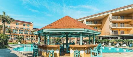 Un espace aménagé au bord de la piscine, comprenant un kiosque, des chaises longues et une piscine.