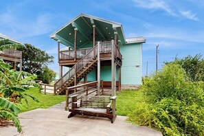 Ein zweistöckiges Gebäude mit einer Holztreppe, die zu einem Balkon führt.