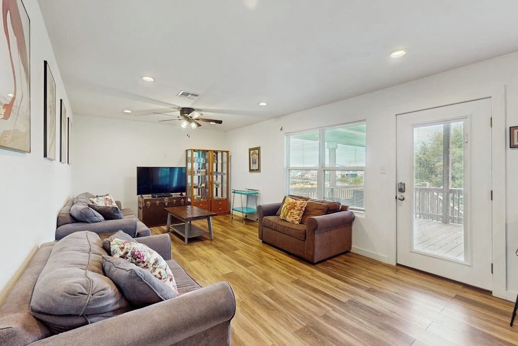 A spacious living room with a flat-screen TV, a coffee table, and a sofa.