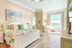 A bedroom with a large bed, a desk, and a view of the sea. - Reserve at St Charles Bay - Grateful and Gracious (Rockport)