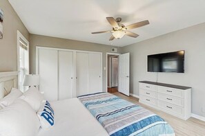 A bedroom with a bed, a ceiling fan, a TV, and a wardrobe. - The Lazy Oak Retreat (Rockport)