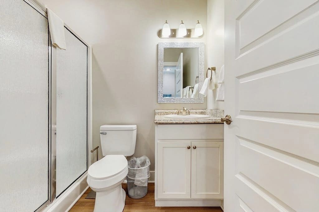 Ein Badezimmer mit Toilette, Waschbecken, Spiegel und Schrank.