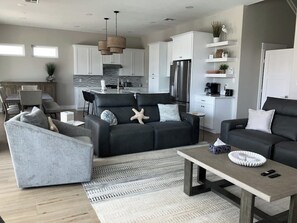 Ein modernes Wohnzimmer mit einer Couch, Sesseln und einem Couchtisch.