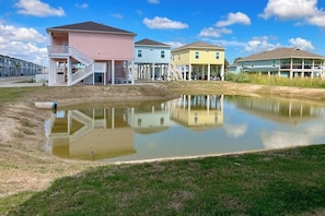A residential area with a pond, houses with balconies, and a clear sky. - Stay Anchored Rockport (Rockport)