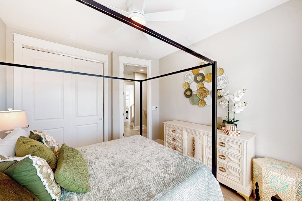 Un dormitorio con cama con dosel, cómoda y decoración de pared.