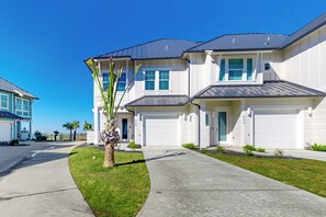A residential building with a two-story structure, a garage, and a well-maintained lawn.