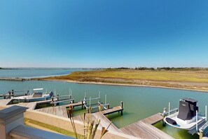 A marina with docked boats, a clear sky, and a view of the water.