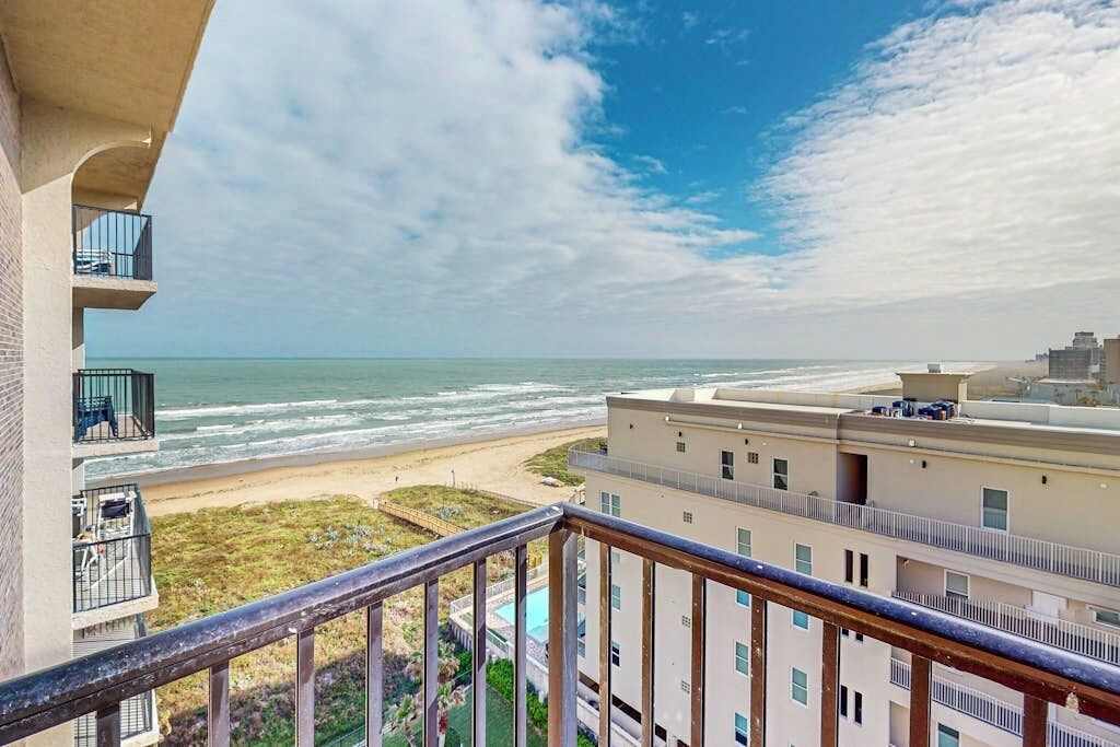 Ein Strandhotel mit Balkon und Meerblick, einem Schwimmbad und Blick auf den Strand.