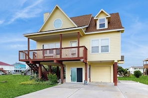Ein zweistöckiges Haus mit Balkon, Garage und Eingangstür.