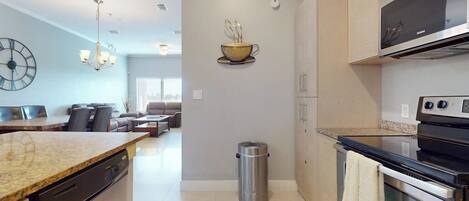 A modern kitchen with a dishwasher, stainless steel appliances, and a microwave.
