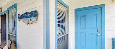 Una casa con una puerta azul y una ventana con persianas.