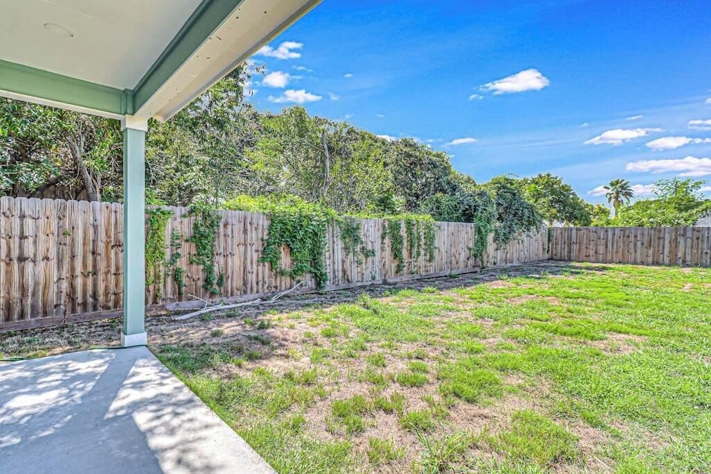 A covered patio area with a view of a backyard.