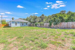 A residential property with a fenced backyard, a single-story house, and a wooden fence. - The Bay Breeze Beauty (Corpus Christi)