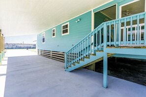 A two-story building with a blue exterior, a covered porch, and a staircase. - Rockport Getaway - Screened Porch, Near the Beach (Rockport)