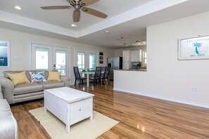 A spacious living area with a sofa, coffee table, and a ceiling fan. - Rockport Getaway - Screened Porch, Near the Beach (Rockport)