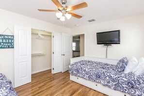 A bedroom with a bed, a ceiling fan, a television, and a wardrobe. - Rockport Getaway - Screened Porch, Near the Beach (Rockport)